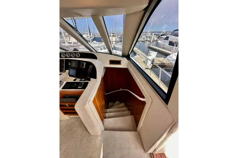 Slide: The Image of Interior view of 2004 Meridian 580 Pilothouse yacht with stairs and marina backdrop. - 124