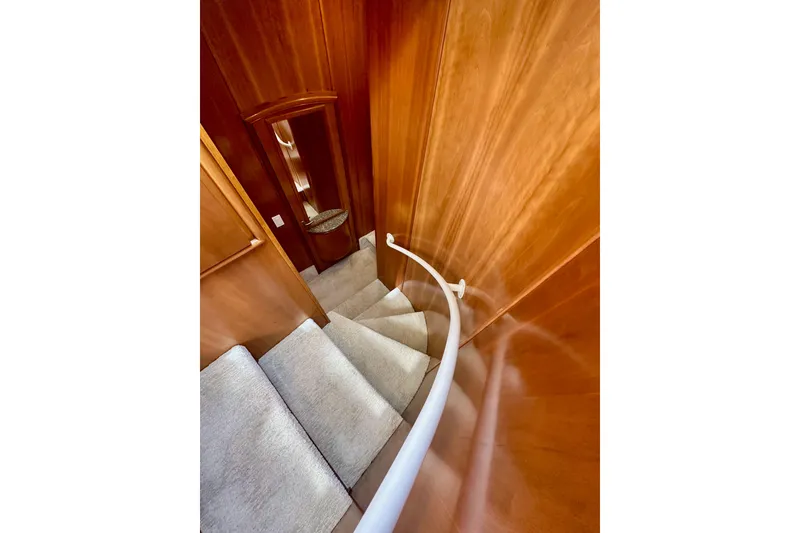 Slide: The Image of Curved staircase inside 2004 Meridian 580 Pilothouse yacht with wooden paneling. - 126