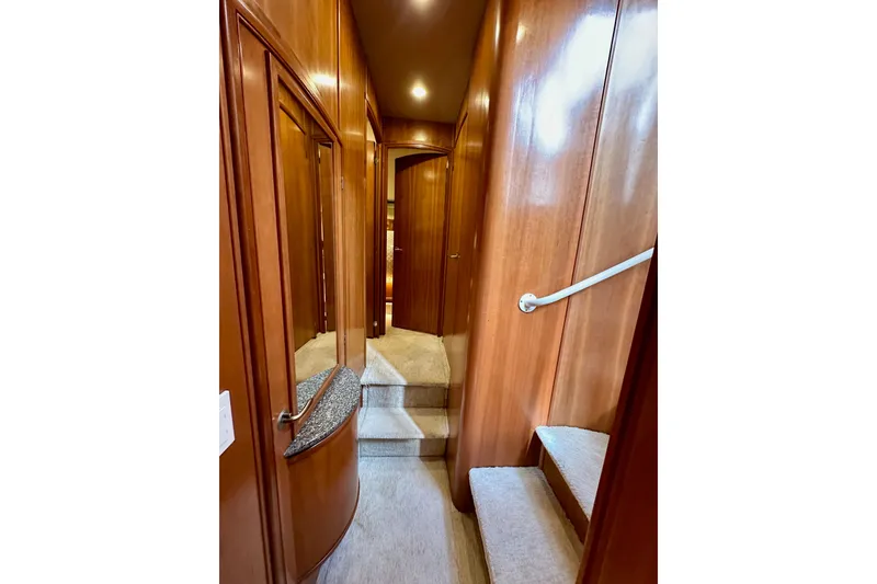 Slide: The Image of Interior hallway of 2004 Meridian 580 Pilothouse yacht with wooden paneling and carpeted stairs. - 138