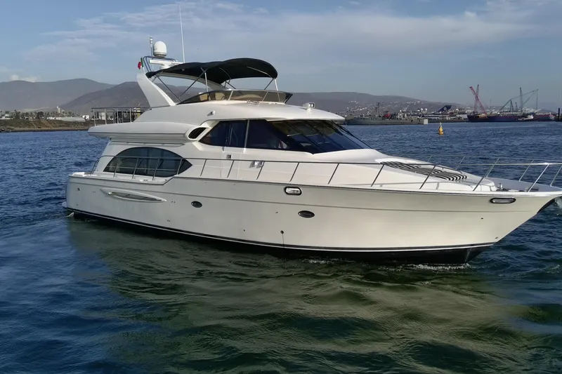 Slide: The Image of 2004 Meridian 580 Pilothouse yacht cruising on calm waters near a harbor. - 2