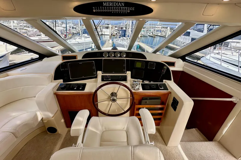 Slide: The Image of Pilothouse interior of 2004 Meridian 580 yacht with steering wheel and navigation equipment. - 88
