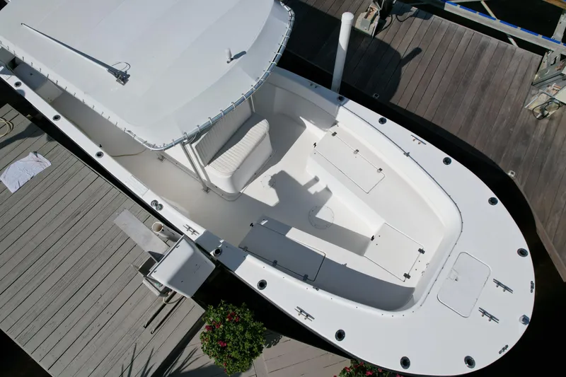 Slide: The Image of 2008 Dusky 278 Center Console boat docked, aerial view, white deck, spacious seating. - 2