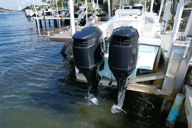 Slide: The Image of 2008 Dusky 278 Center Console boat with dual outboard motors docked by the water. - 37