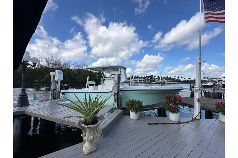 Slide: The Image of 2008 Dusky 278 Center Console boat docked, surrounded by potted plants and American flag. - 39