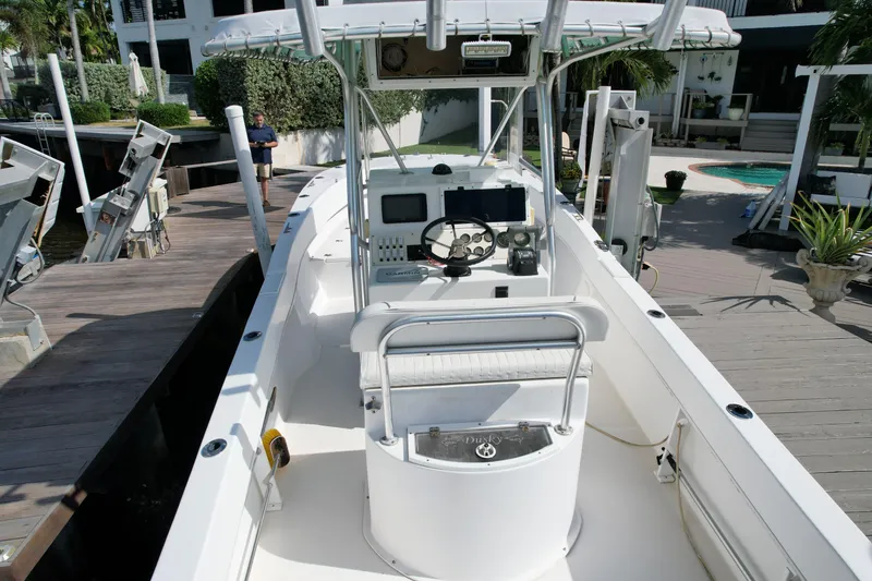 Slide: The Image of 2008 Dusky 278 Center Console boat docked, featuring helm and seating area. - 7
