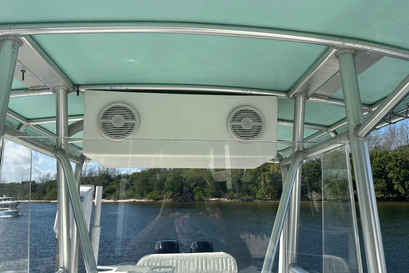 Slide: The Image of 2008 Dusky 278 Center Console boat with speakers under a teal canopy. - 11