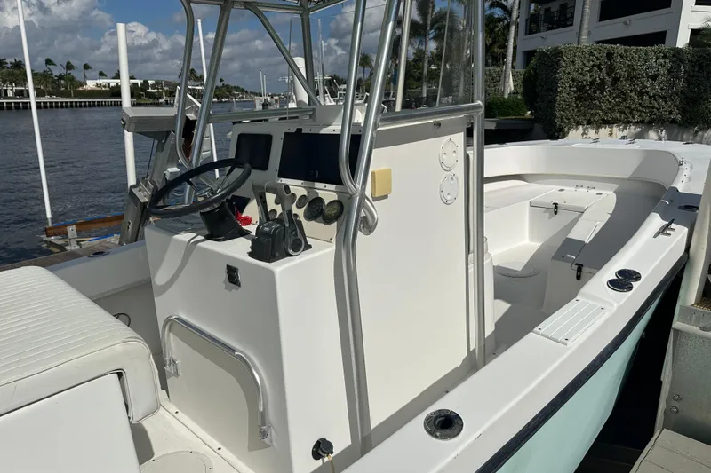 Slide: The Image of 2008 Dusky 278 Center Console boat docked, featuring steering console and seating area. - 12