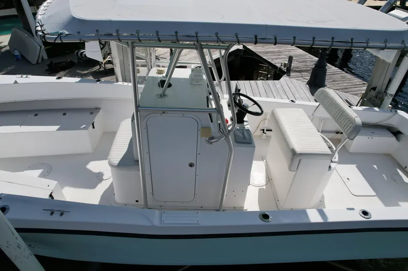 Slide: The Image of 2008 Dusky 278 Center Console boat with white seating and steering wheel, docked by the water. - 3