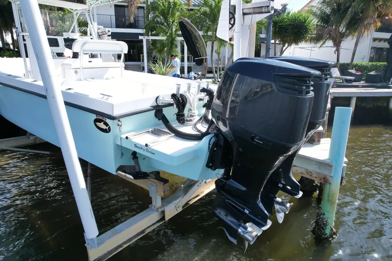 Slide: The Image of 2008 Dusky 278 Center Console boat with dual outboard motors docked by water. - 35