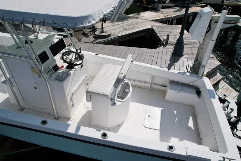 Slide: The Image of 2008 Dusky 278 Center Console boat interior at dock, featuring helm and seating area. - 4