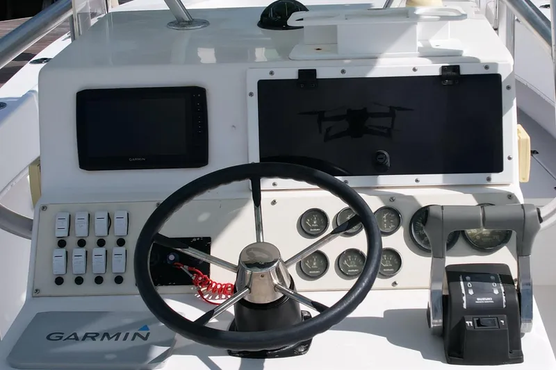 Slide: The Image of 2008 Dusky 278 Center Console boat dashboard with Garmin navigation and Suzuki controls. - 9