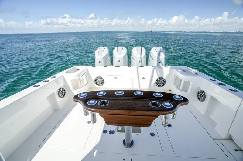 Slide: The Image of 2024 SeaVee 400Z boat deck with quad engines, ocean view, and fishing rod holders. - 14