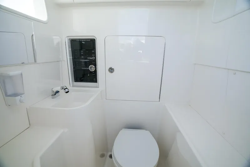 Slide: The Image of 2024 SeaVee 400Z boat interior bathroom with sink, toilet, and control panel. - 8