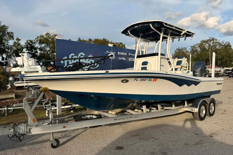 The Image of 2019 Ranger 2510 Bay Ranger boat on trailer, parked outdoors under clear sky. - 0