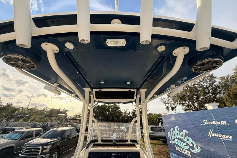 Slide: The Image of 2019 Ranger 2510 Bay Ranger boat with T-top and rod holders, parked outdoors. - 7