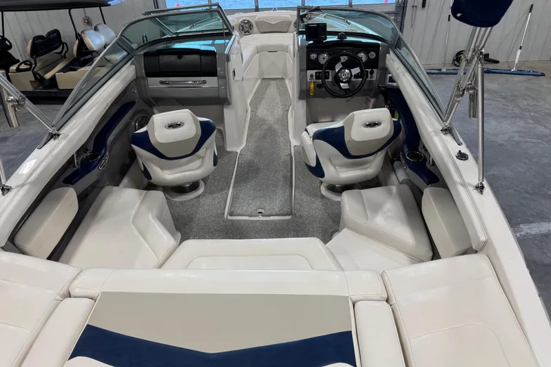 Slide: The Image of 2012 Chaparral 216 SSi boat interior with white and blue seating, steering wheel, and dashboard. - 21