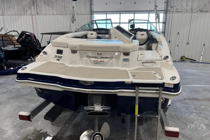 Slide: The Image of 2012 Chaparral 216 SSi boat in a garage, rear view with swim platform and ladder. - 5