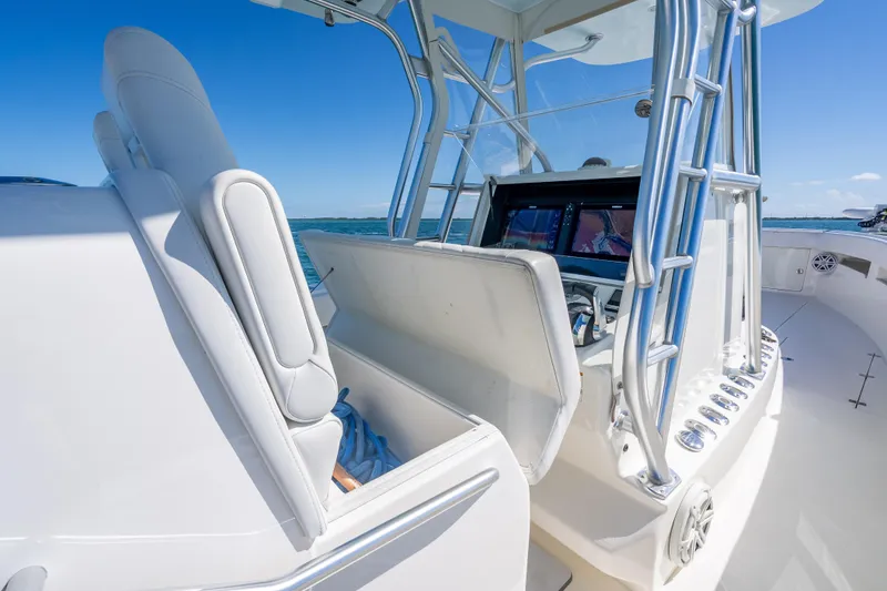 Slide: The Image of 2019 SeaVee 340Z boat interior with helm station and seating, under clear blue sky. - 15