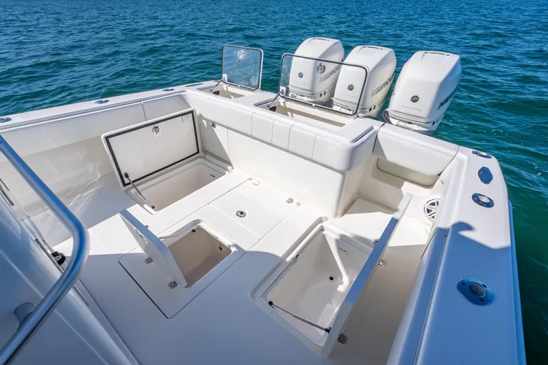 Slide: The Image of 2019 SeaVee 340Z boat with open storage compartments and triple outboard engines on blue water. - 21