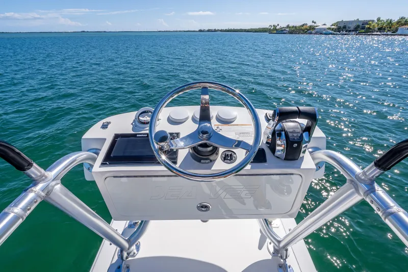 Slide: The Image of 2019 SeaVee 340Z boat helm with steering wheel and controls on open water. - 36