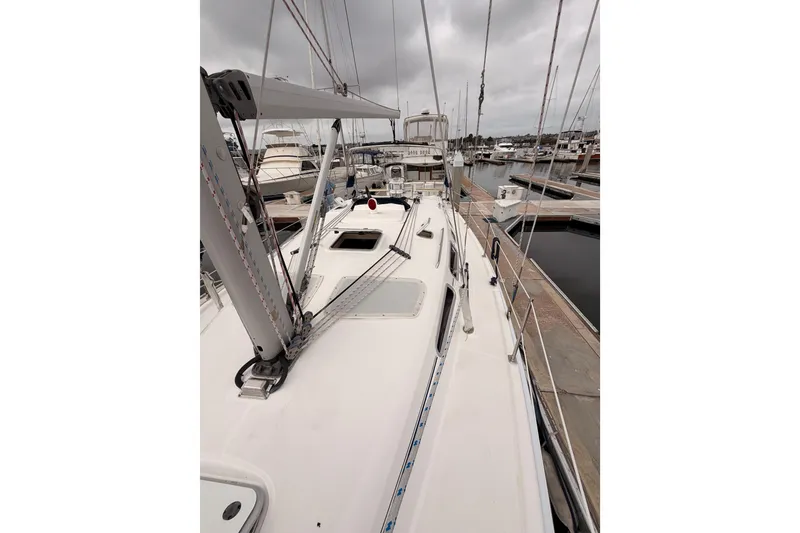 Slide: The Image of 2009 Hunter 38 sailboat docked at marina under cloudy skies. - 15