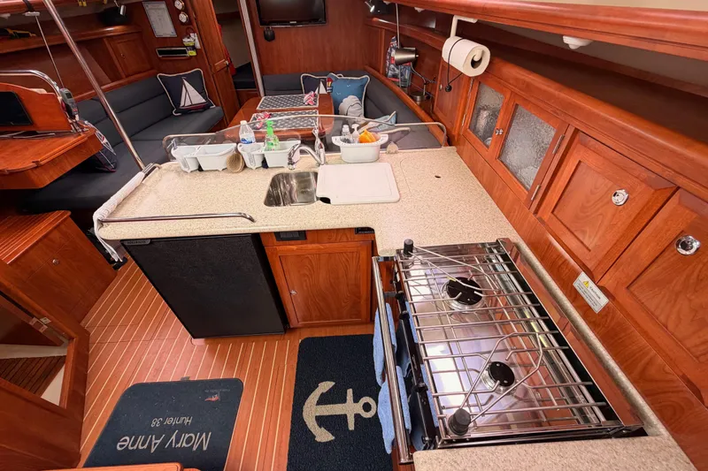 Slide: The Image of Interior of 2009 Hunter 38 sailboat featuring a compact kitchen with stove and sink. - 27