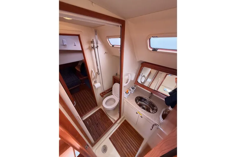 Slide: The Image of 2009 Hunter 38 yacht bathroom with shower, toilet, sink, and wooden flooring. - 30