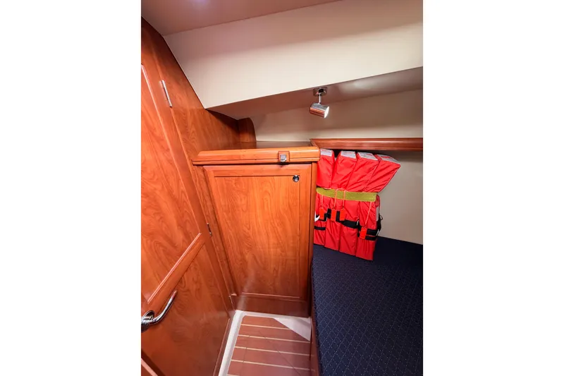 Slide: The Image of Interior of 2009 Hunter 38 sailboat with wooden cabinetry and life jackets. - 42