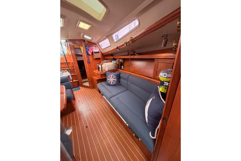 Slide: The Image of 2009 Hunter 38 yacht interior with wooden flooring and blue seating. - 43