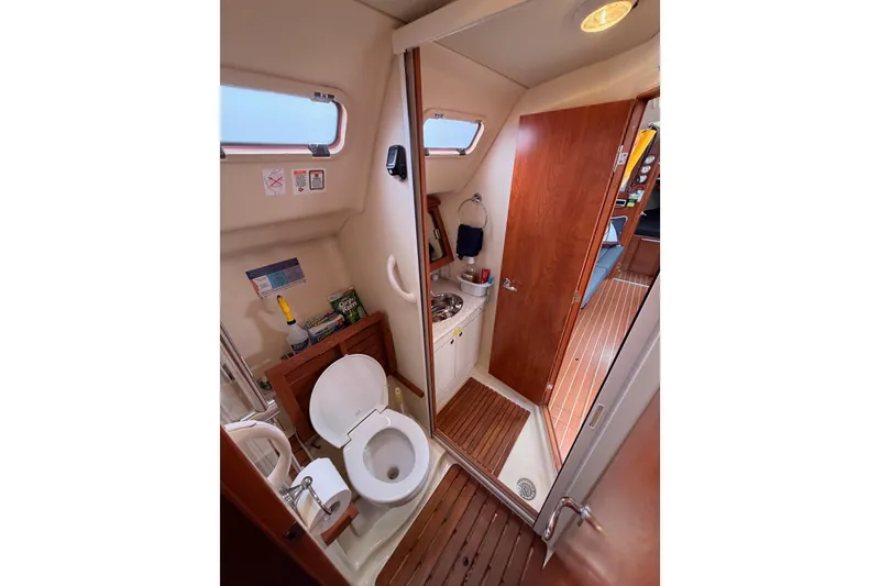 Slide: The Image of Interior of 2009 Hunter 38 sailboat bathroom with toilet, sink, and wooden accents. - 51