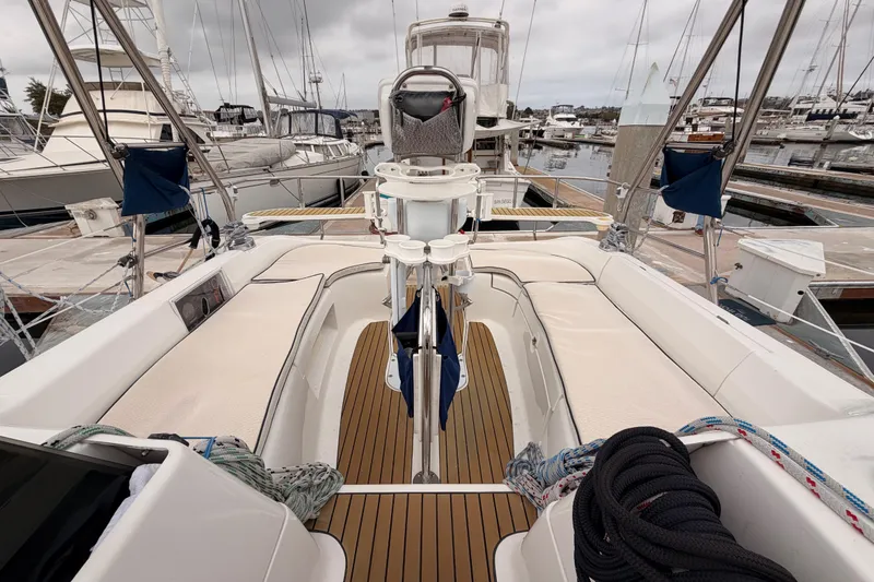 Slide: The Image of 2009 Hunter 38 sailboat with teak deck, docked in a marina under cloudy skies. - 53