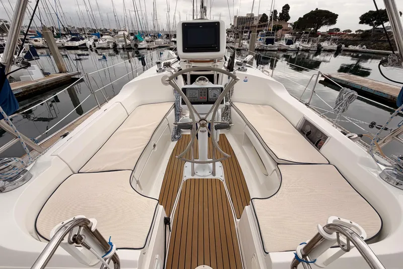 Slide: The Image of 2009 Hunter 38 sailboat cockpit with cushioned seating and navigation equipment at marina. - 6