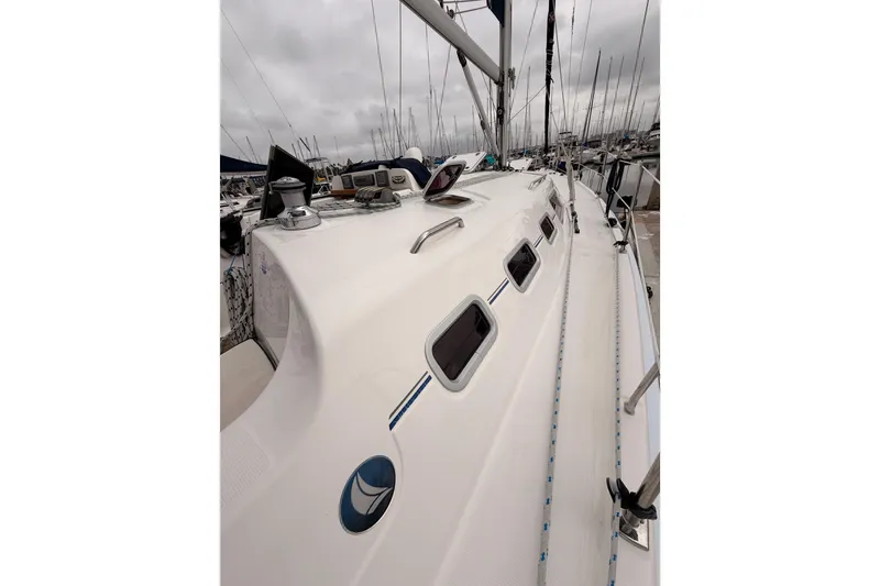 Slide: The Image of 2009 Hunter 38 sailboat deck with winches and hatches in a marina. - 8
