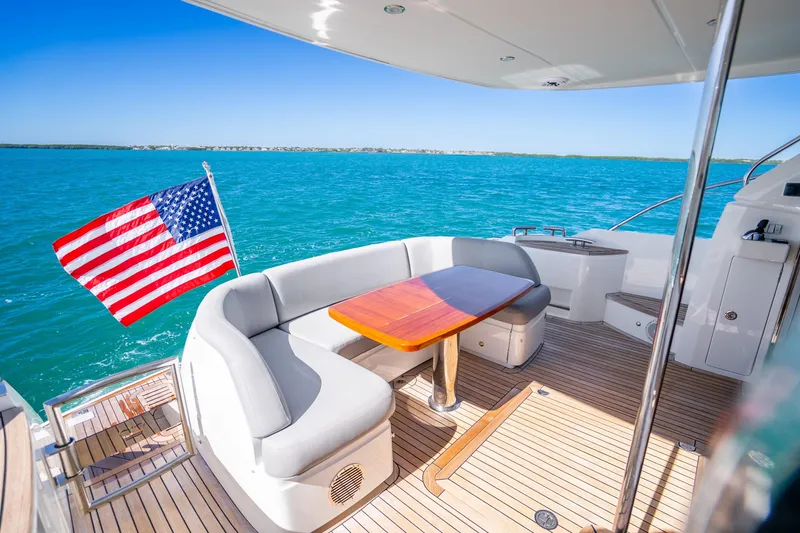 Slide: The Image of Luxurious 2018 Princess F49 yacht deck with seating, table, and American flag on open sea. - 44