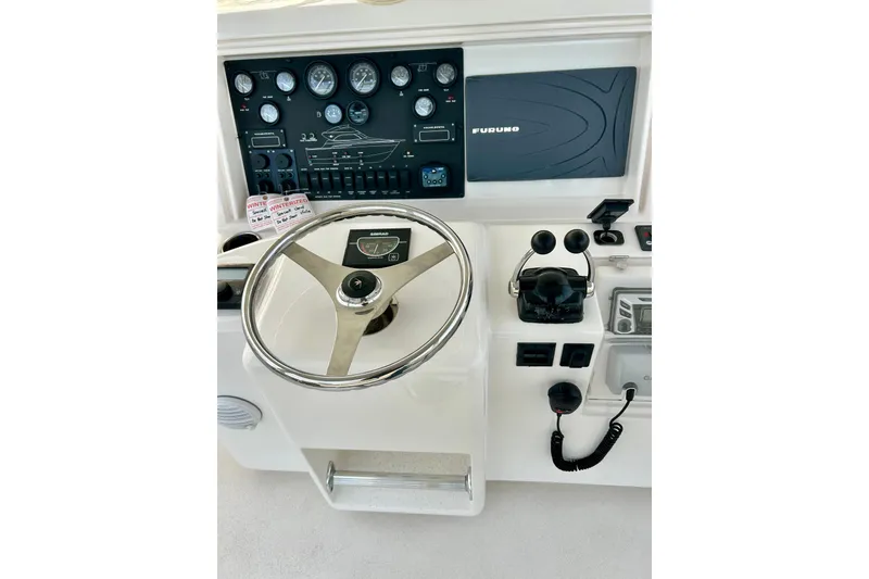 Slide: The Image of 2005 Bertram 390 Convertible helm with steering wheel and navigation controls. - 17