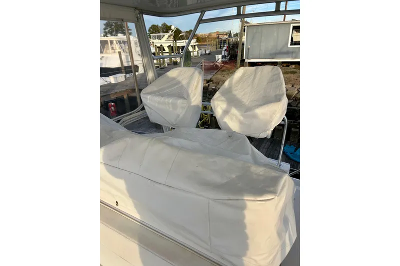 Slide: The Image of 2005 Bertram 390 Convertible boat interior with covered seating at dock. - 23
