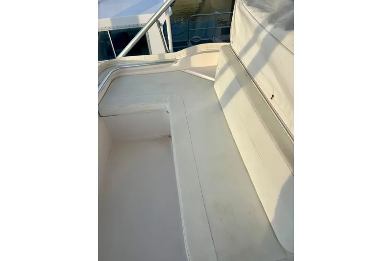 Slide: The Image of 2005 Bertram 390 Convertible boat seating area with white upholstery and railing. - 24