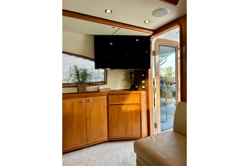 Slide: The Image of Interior of 2005 Bertram 390 Convertible yacht with wooden cabinetry and mounted TV. - 40