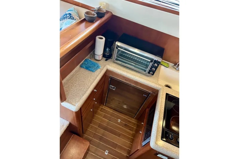Slide: The Image of 2005 Bertram 390 Convertible yacht kitchen with appliances and wooden cabinetry. - 45