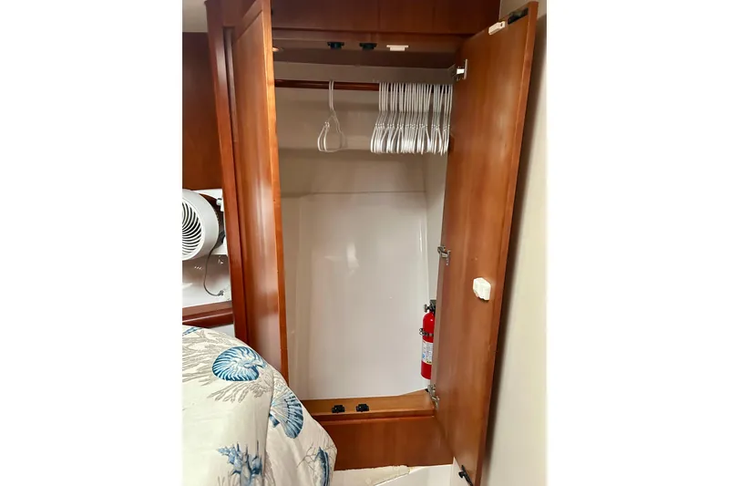 Slide: The Image of 2005 Bertram 390 Convertible cabin closet with hangers and fire extinguisher. - 54