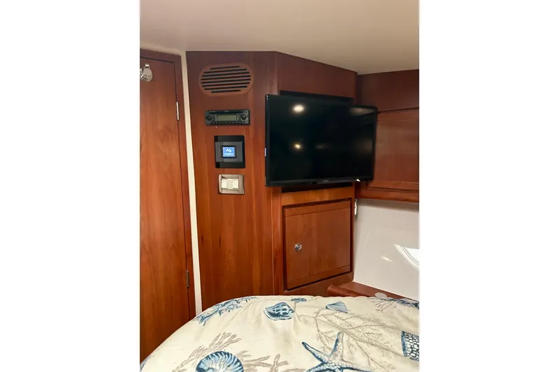 Slide: The Image of Interior of 2005 Bertram 390 Convertible with TV and wooden cabinetry. - 56