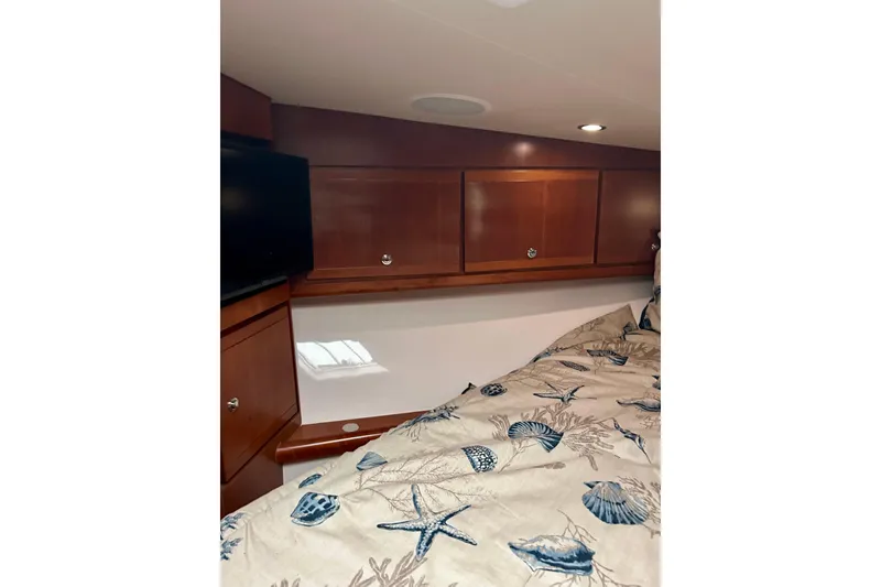 Slide: The Image of Cozy cabin interior of 2005 Bertram 390 Convertible with wooden cabinets and patterned bedding. - 57
