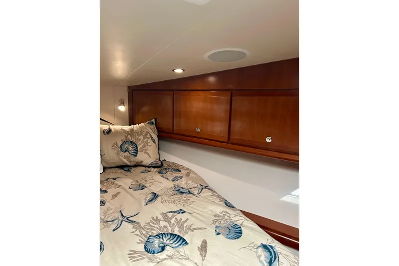 Slide: The Image of Cozy cabin interior of 2005 Bertram 390 Convertible with nautical-themed bedding. - 58