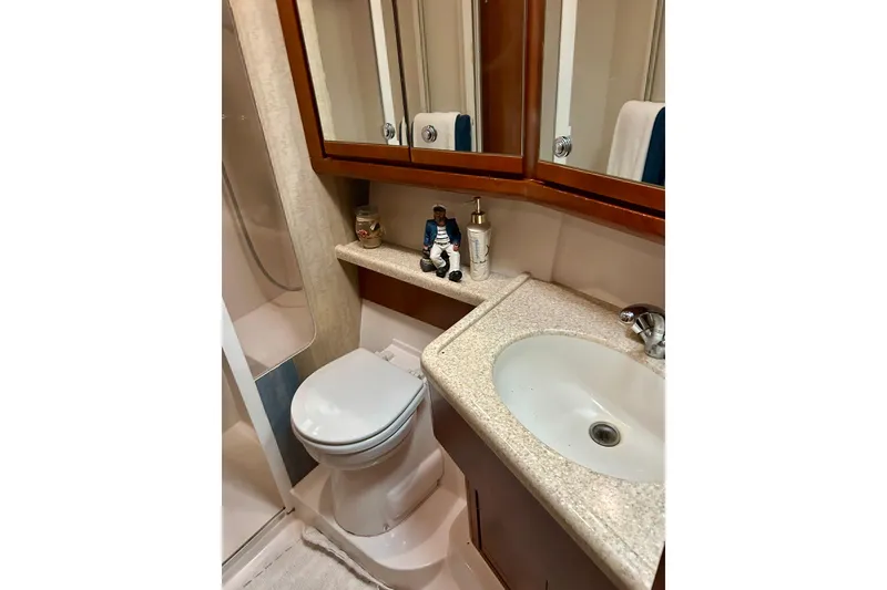 Slide: The Image of Bathroom interior of 2005 Bertram 390 Convertible yacht with sink, toilet, and shower. - 59