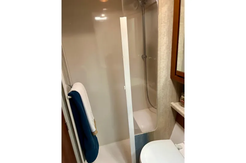 Slide: The Image of Shower area in 2005 Bertram 390 Convertible yacht bathroom, featuring modern fixtures and towel rack. - 60