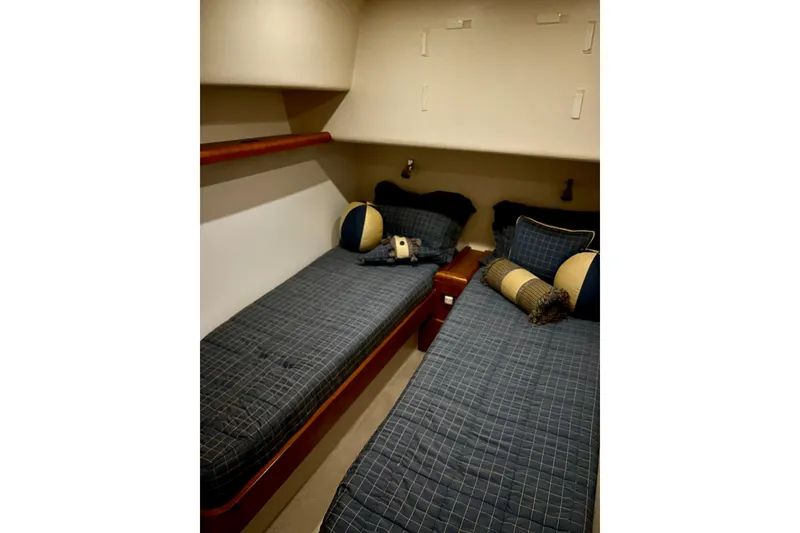 Slide: The Image of 2005 Bertram 390 Convertible cabin with twin beds and nautical-themed decor. - 61