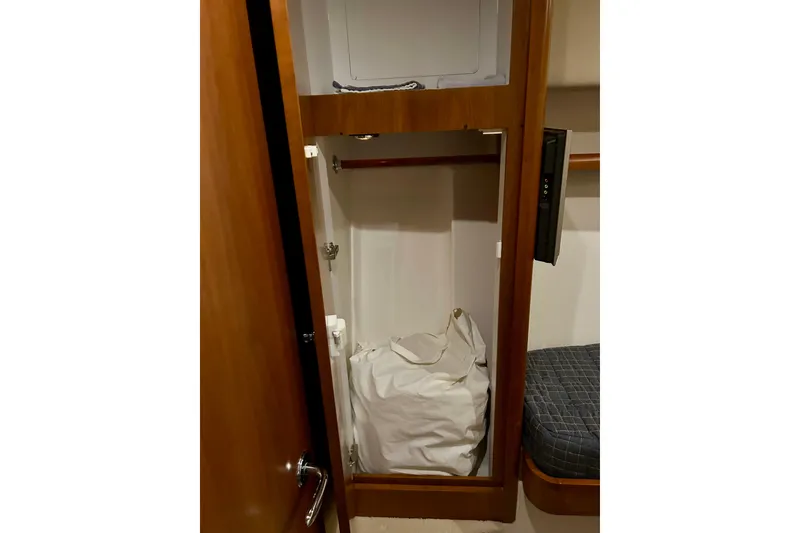 Slide: The Image of 2005 Bertram 390 Convertible interior closet with storage bag and wooden finish. - 63