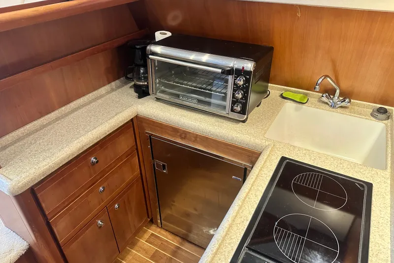 Slide: The Image of 2005 Bertram 390 Convertible kitchen with toaster oven, sink, and stovetop. - 66
