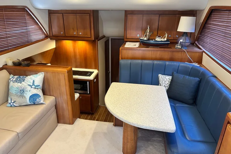 Slide: The Image of Interior of 2005 Bertram 390 Convertible yacht with cozy seating and nautical decor. - 67