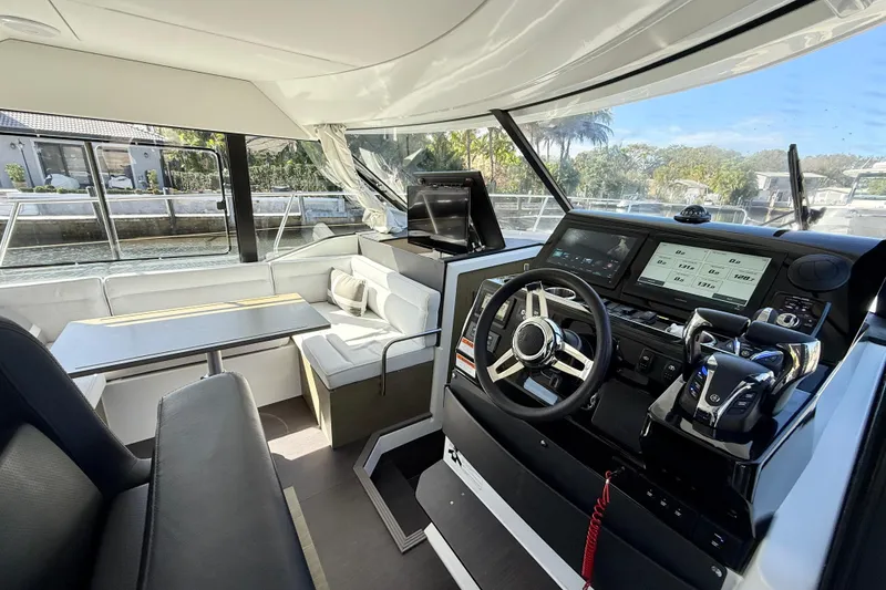 Slide: The Image of 2024 Jeanneau NC 1295 Fly interior with modern helm and seating area. - 15
